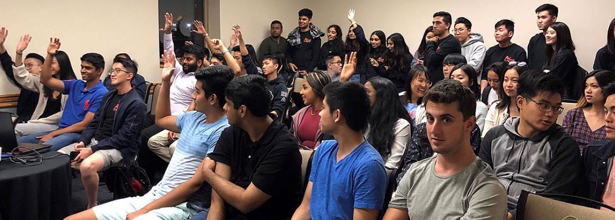 Members of Ascend raising their hands in a classroom