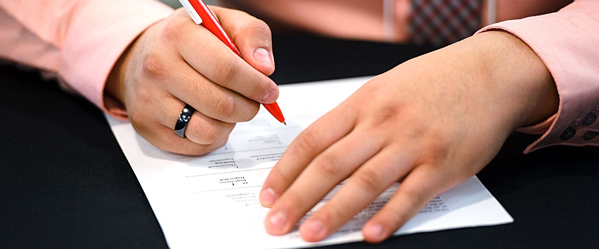 Closeup of hands filling out a form.