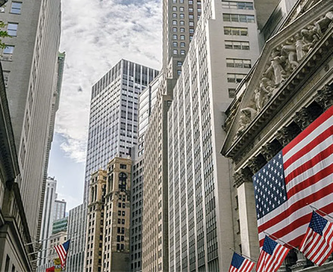 Buildings on Wall Street with the US flag