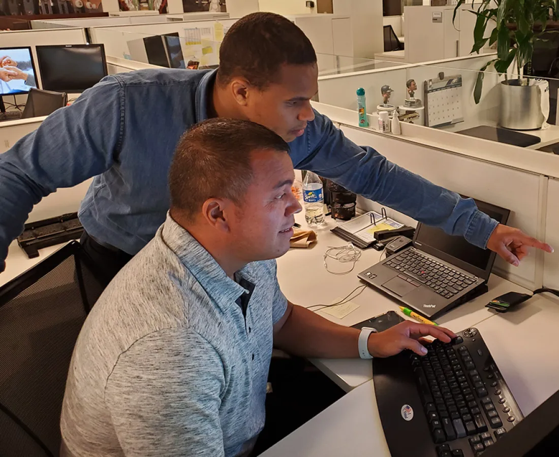 Student showing co-worker something on his computer