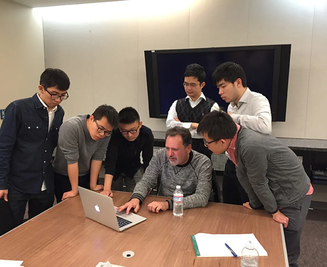 students working with a professor on a project