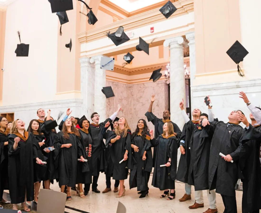 RBS graduates throwing their graduation caps in the air
