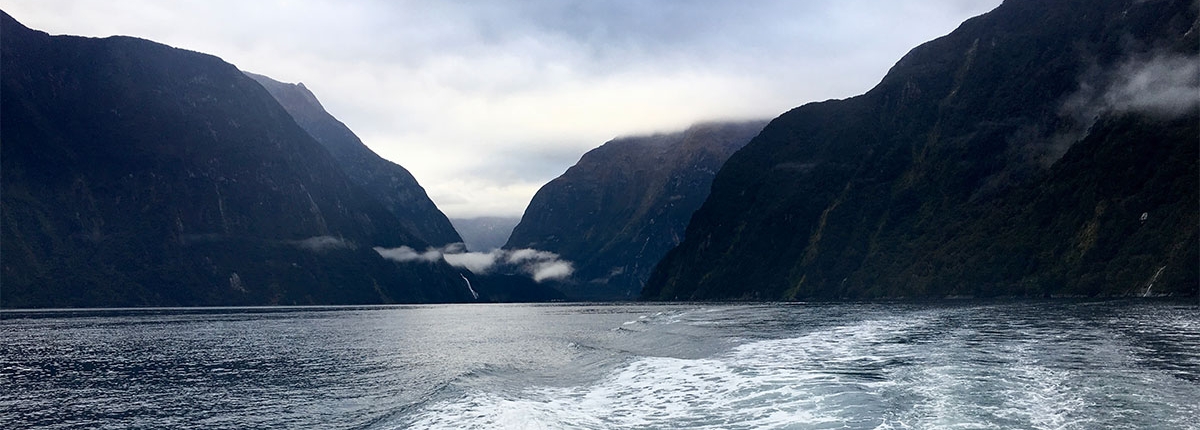 Mountains coming out of the sky and standing there over water