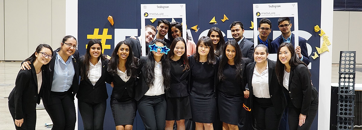 Members pose together. Some are posing behind novelty instagram frames.