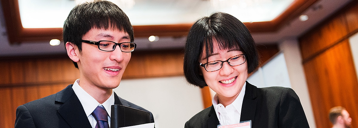 Two students looking through paperwork at a career fair