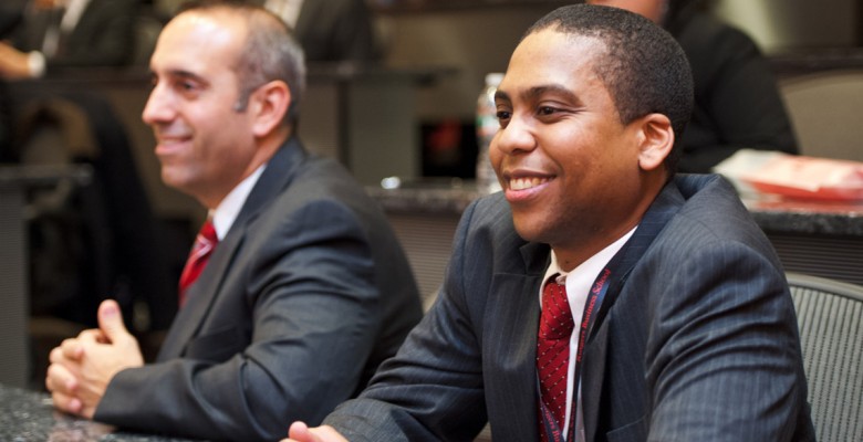 Two participants of the 2012 competition sit together smiling with their hands folded