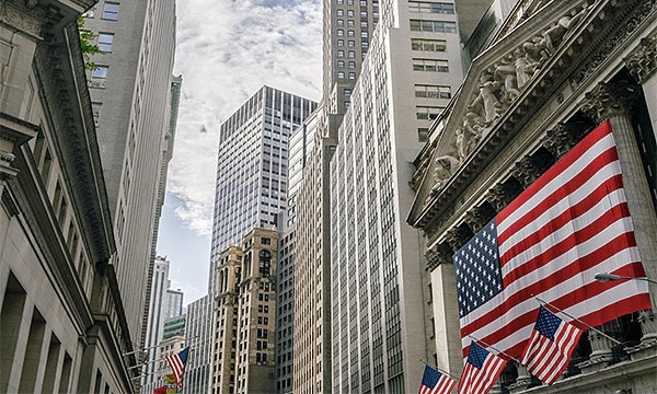 Buildings on Wall Street with the US flag