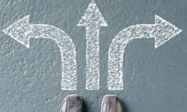 someone standing at three arrows pointing left, right and forward