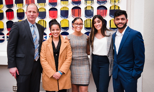 Students posing and smiling with the director of the center for real estate