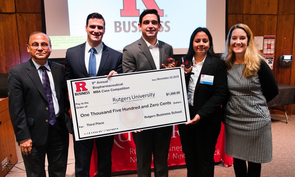 Students holding check after winning 3rd place in a case competition