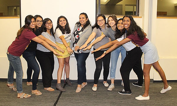 Members pose holding their hands out in unison