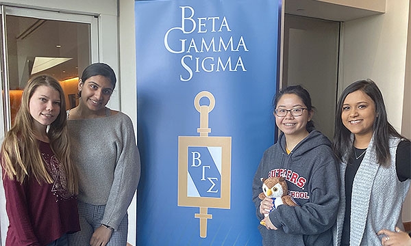 Members pose in front of a BGS banner