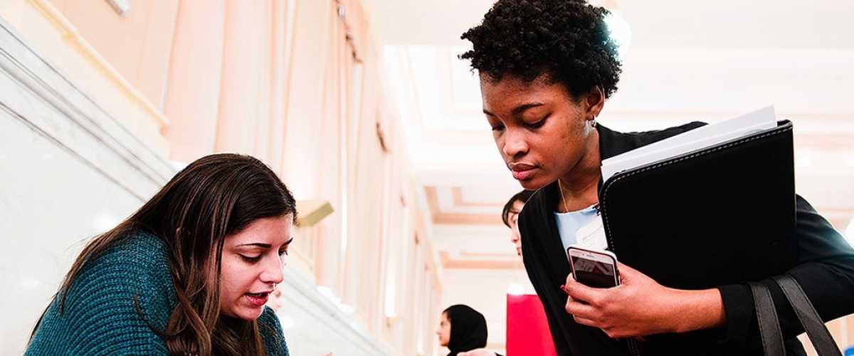 female student speaking with female employer at career fair