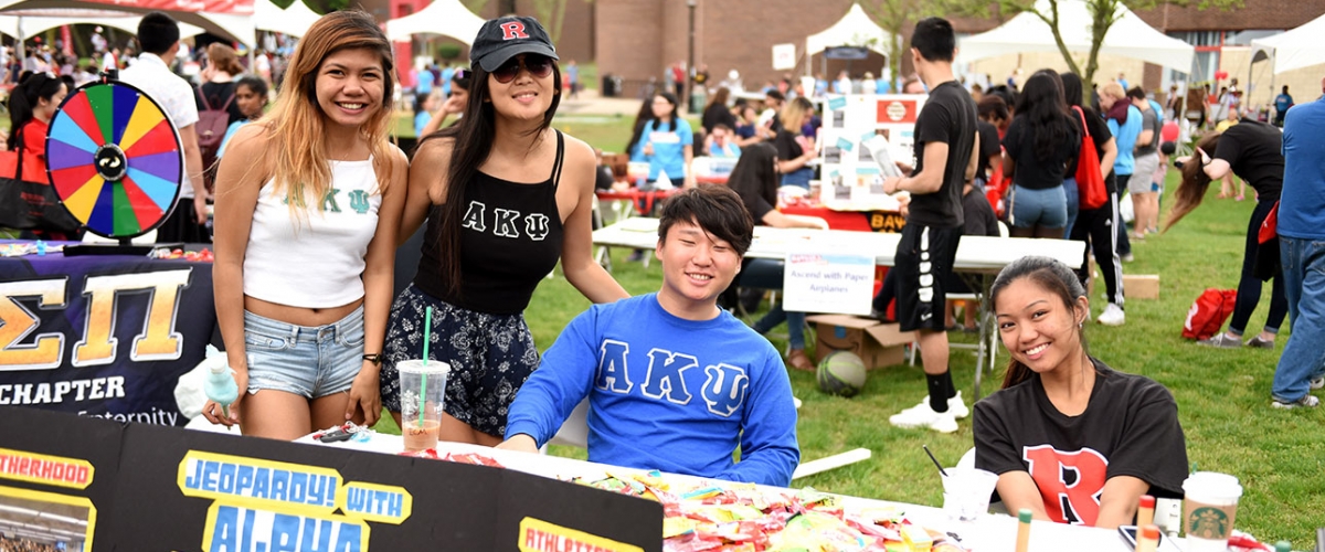 Members of Alpha Kappa Psi pose with their Jeopardy game table