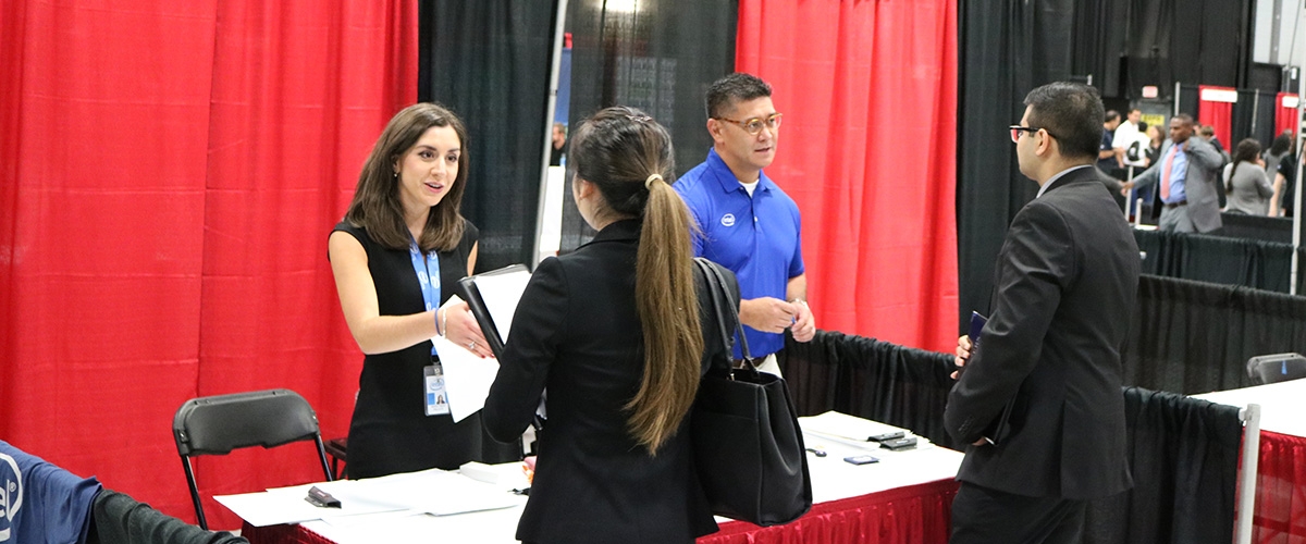 Students and employers speaking at a career fair
