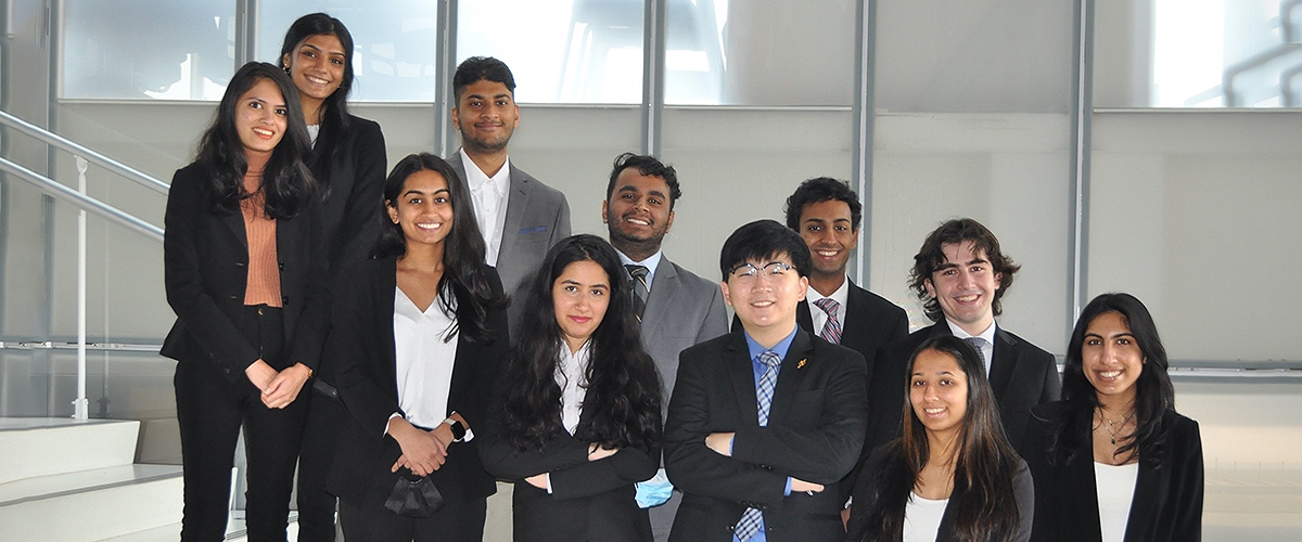 BGS members pose in front of a BGS plaque