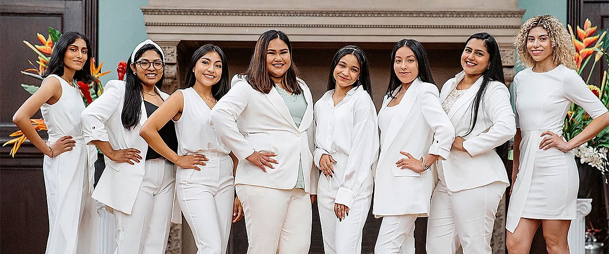 Members pose together dressed in white